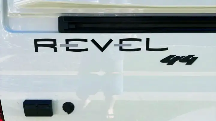 Close-up of the Winnebago Revel 4x4 logo on a white adventure van, symbolizing off-grid travel and rugged capability near Grand Canyon National Park.
