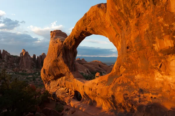 Natural sandstone arch glowing at sunset in Arches National Park, Utah, one of the top places to explore when planning the best time to visit Arches National Park.
