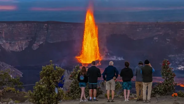 Visitors watching an active Kīlauea lava fountain at Hawaiʻi Volcanoes National Park on the Big Island of Hawaii.